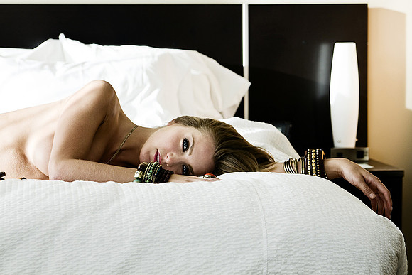 Boudoir photography of woman in artful boudoir pose on bed