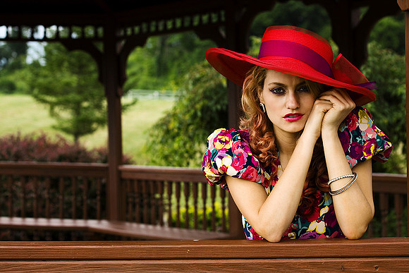 Classic fashion photo of woman in floral dress and red hat