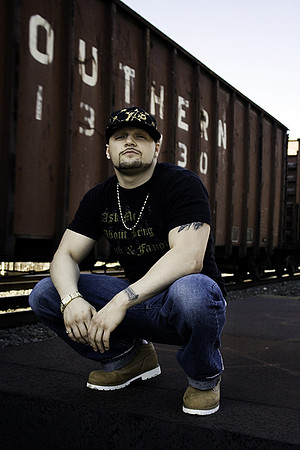 Urban fashion photography of male in jeans and black shirt near trains