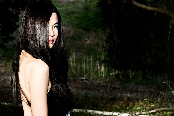 Outdoor beauty photo of woman with long hair partially covering her face
